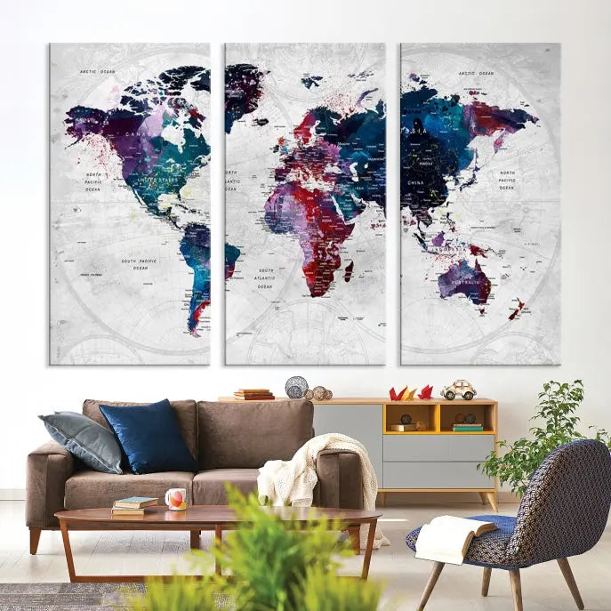 The "World Map Wall Art Watercolor Wall Art Canvas Print," a triptych featuring a vibrant world map, is gallery wrapped on museum-quality canvas and enhances the dark wall.