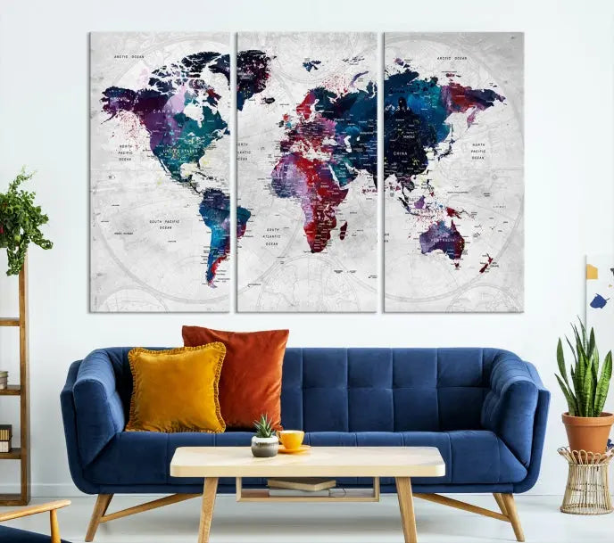 The "World Map Wall Art Watercolor Wall Art Canvas Print," a triptych featuring a vibrant world map, is gallery wrapped on museum-quality canvas and enhances the dark wall.