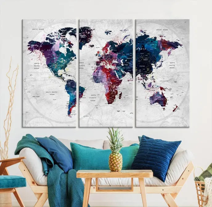 The "World Map Wall Art Watercolor Wall Art Canvas Print," a triptych featuring a vibrant world map, is gallery wrapped on museum-quality canvas and enhances the dark wall.