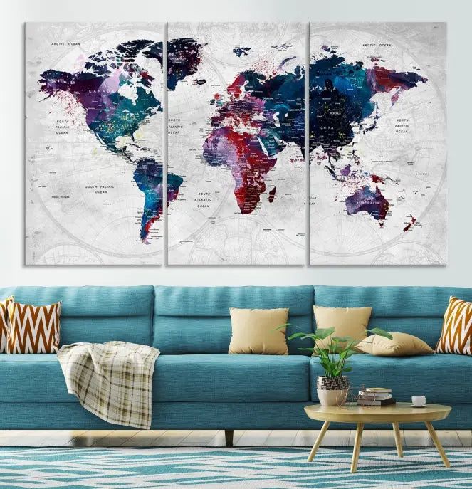 The "World Map Wall Art Watercolor Wall Art Canvas Print," a triptych featuring a vibrant world map, is gallery wrapped on museum-quality canvas and enhances the dark wall.