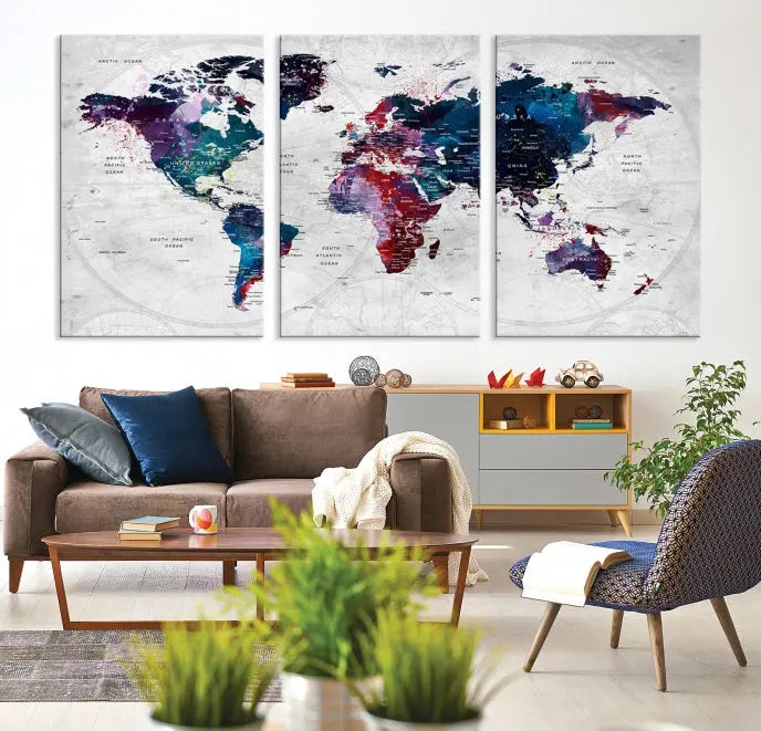 The "World Map Wall Art Watercolor Wall Art Canvas Print," a triptych featuring a vibrant world map, is gallery wrapped on museum-quality canvas and enhances the dark wall.