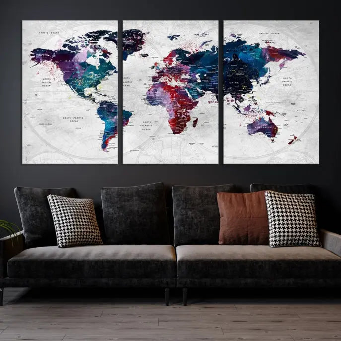 The "World Map Wall Art Watercolor Wall Art Canvas Print," a triptych featuring a vibrant world map, is gallery wrapped on museum-quality canvas and enhances the dark wall.