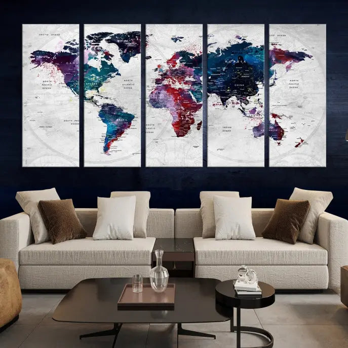 The "World Map Wall Art Watercolor Wall Art Canvas Print," a triptych featuring a vibrant world map, is gallery wrapped on museum-quality canvas and enhances the dark wall.