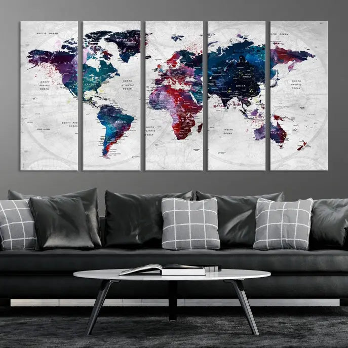 The "World Map Wall Art Watercolor Wall Art Canvas Print," a triptych featuring a vibrant world map, is gallery wrapped on museum-quality canvas and enhances the dark wall.