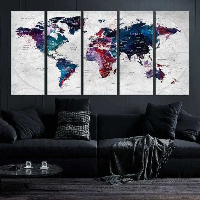 The "World Map Wall Art Watercolor Wall Art Canvas Print," a triptych featuring a vibrant world map, is gallery wrapped on museum-quality canvas and enhances the dark wall.