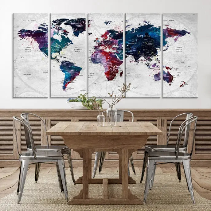 The "World Map Wall Art Watercolor Wall Art Canvas Print," a triptych featuring a vibrant world map, is gallery wrapped on museum-quality canvas and enhances the dark wall.