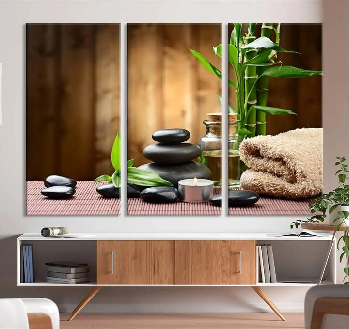 The Zen Serenity Triptych Canvas Art adorns the wall, featuring a pink lotus flower, balancing stones, towels, and bamboo.