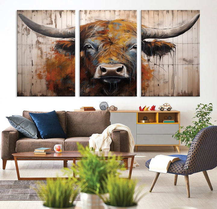 The "Abstract Bull Highland Cow Canvas Wall Art Print," displayed as a three-panel piece, adds vibrant rustic charm to a living room. Its depiction of a large, horned bull beautifully complements the elegance of modern farmhouse decor.