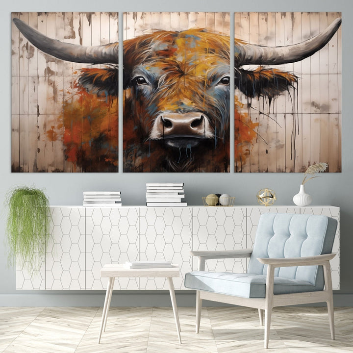 The "Abstract Bull Highland Cow Canvas Wall Art Print," displayed as a three-panel piece, adds vibrant rustic charm to a living room. Its depiction of a large, horned bull beautifully complements the elegance of modern farmhouse decor.