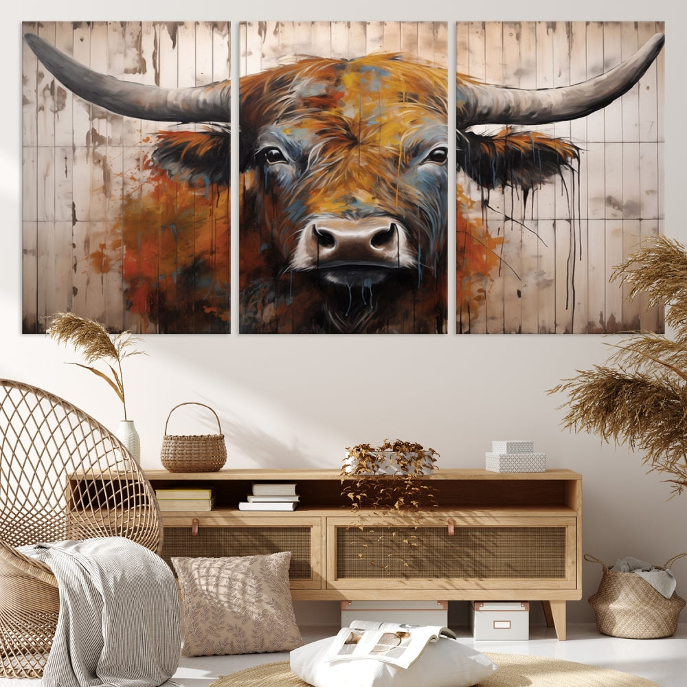 The "Abstract Bull Highland Cow Canvas Wall Art Print," displayed as a three-panel piece, adds vibrant rustic charm to a living room. Its depiction of a large, horned bull beautifully complements the elegance of modern farmhouse decor.