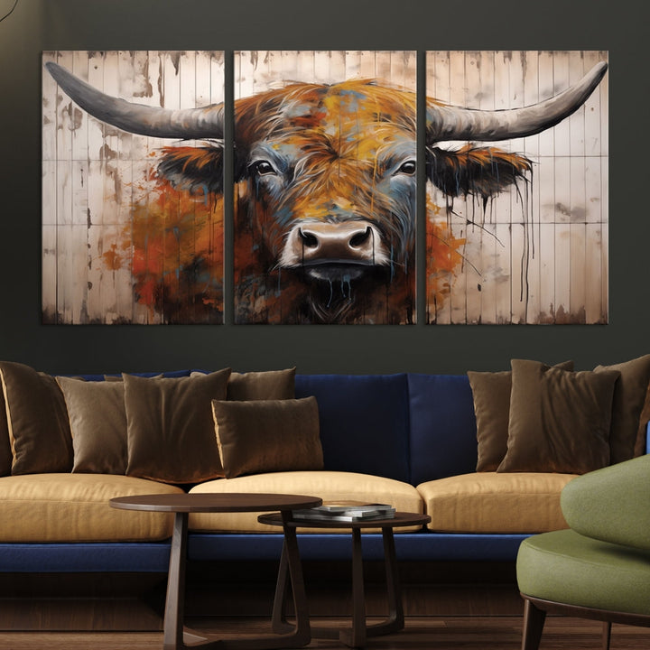 The "Abstract Bull Highland Cow Canvas Wall Art Print," displayed as a three-panel piece, adds vibrant rustic charm to a living room. Its depiction of a large, horned bull beautifully complements the elegance of modern farmhouse decor.