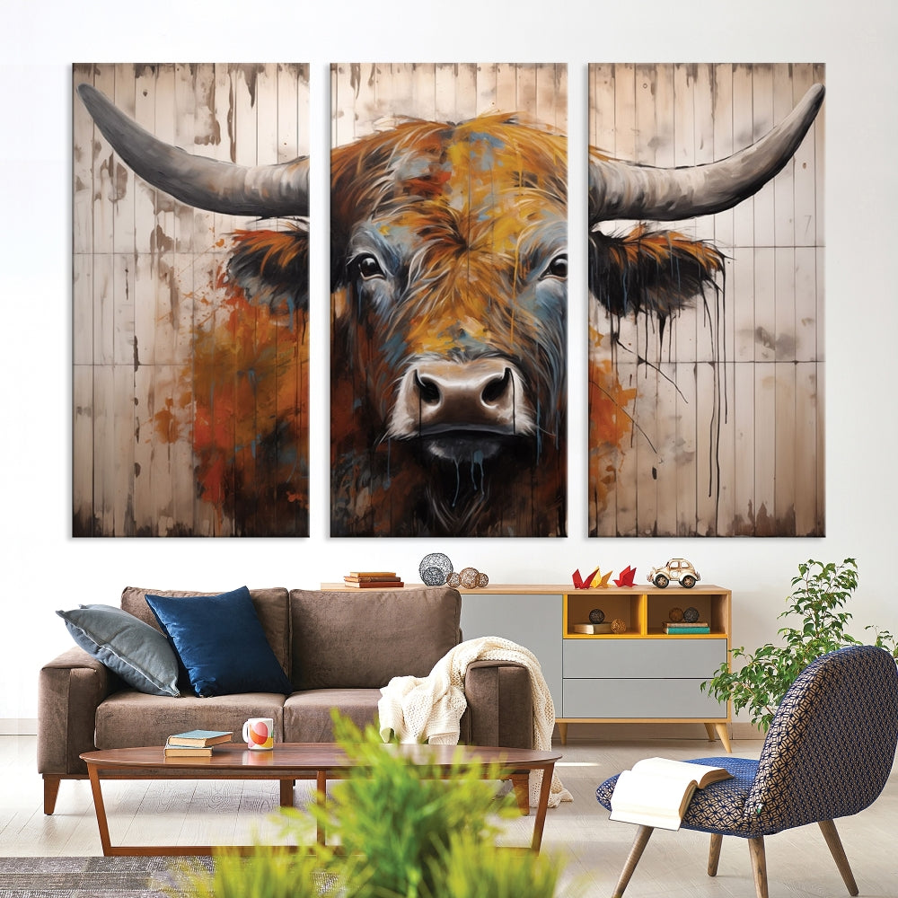 The "Abstract Bull Highland Cow Canvas Wall Art Print," displayed as a three-panel piece, adds vibrant rustic charm to a living room. Its depiction of a large, horned bull beautifully complements the elegance of modern farmhouse decor.