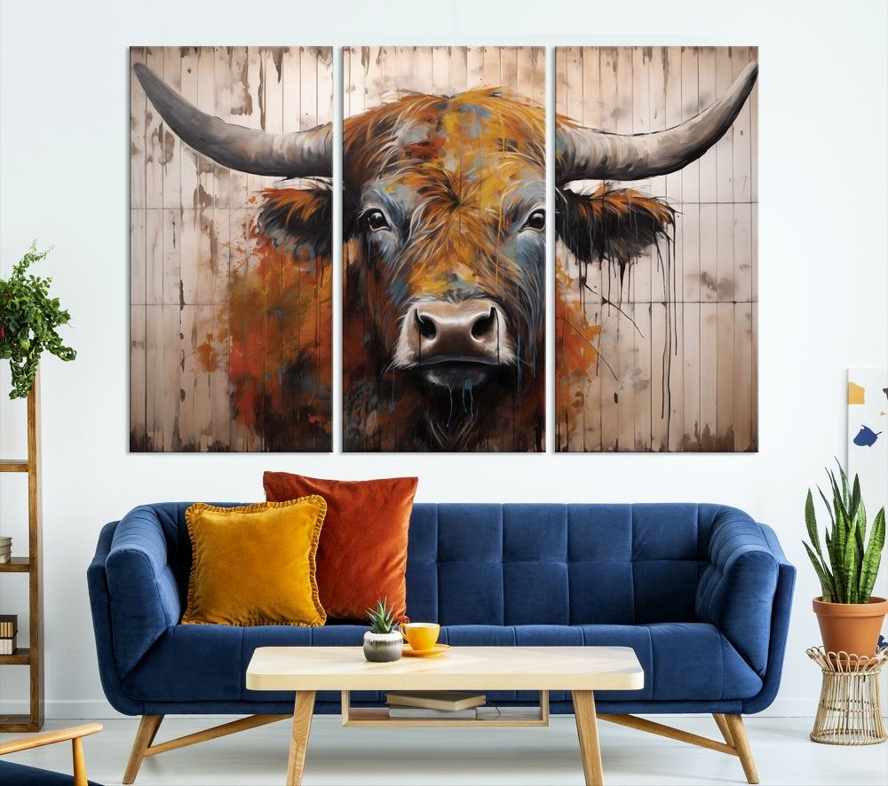 The "Abstract Bull Highland Cow Canvas Wall Art Print," displayed as a three-panel piece, adds vibrant rustic charm to a living room. Its depiction of a large, horned bull beautifully complements the elegance of modern farmhouse decor.