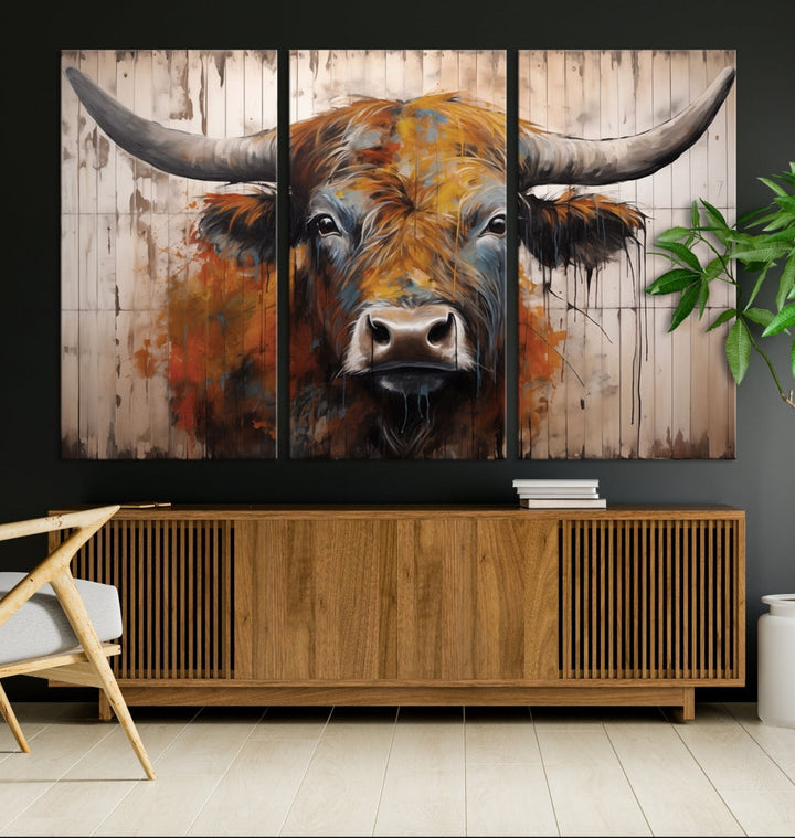 The "Abstract Bull Highland Cow Canvas Wall Art Print," displayed as a three-panel piece, adds vibrant rustic charm to a living room. Its depiction of a large, horned bull beautifully complements the elegance of modern farmhouse decor.