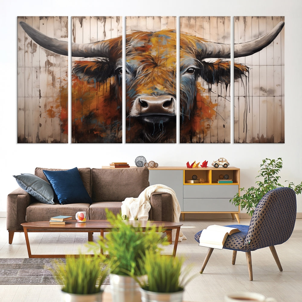 The "Abstract Bull Highland Cow Canvas Wall Art Print," displayed as a three-panel piece, adds vibrant rustic charm to a living room. Its depiction of a large, horned bull beautifully complements the elegance of modern farmhouse decor.