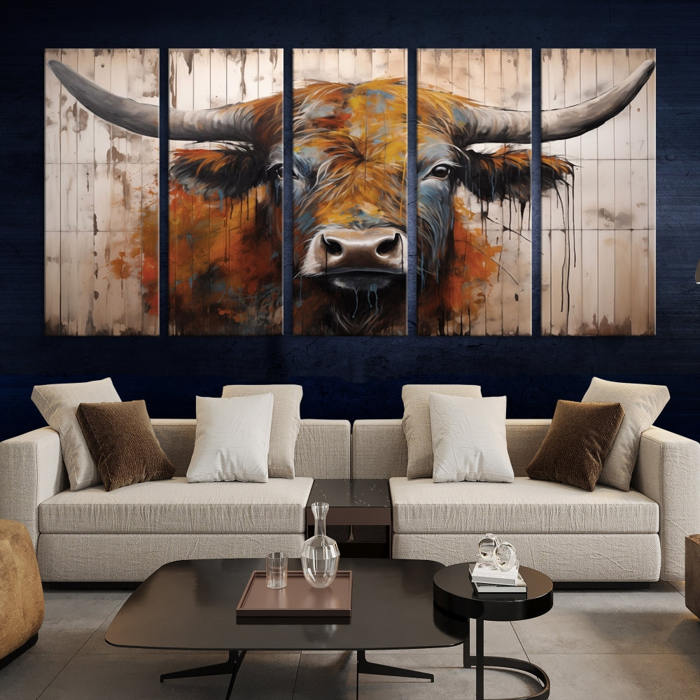 The "Abstract Bull Highland Cow Canvas Wall Art Print," displayed as a three-panel piece, adds vibrant rustic charm to a living room. Its depiction of a large, horned bull beautifully complements the elegance of modern farmhouse decor.