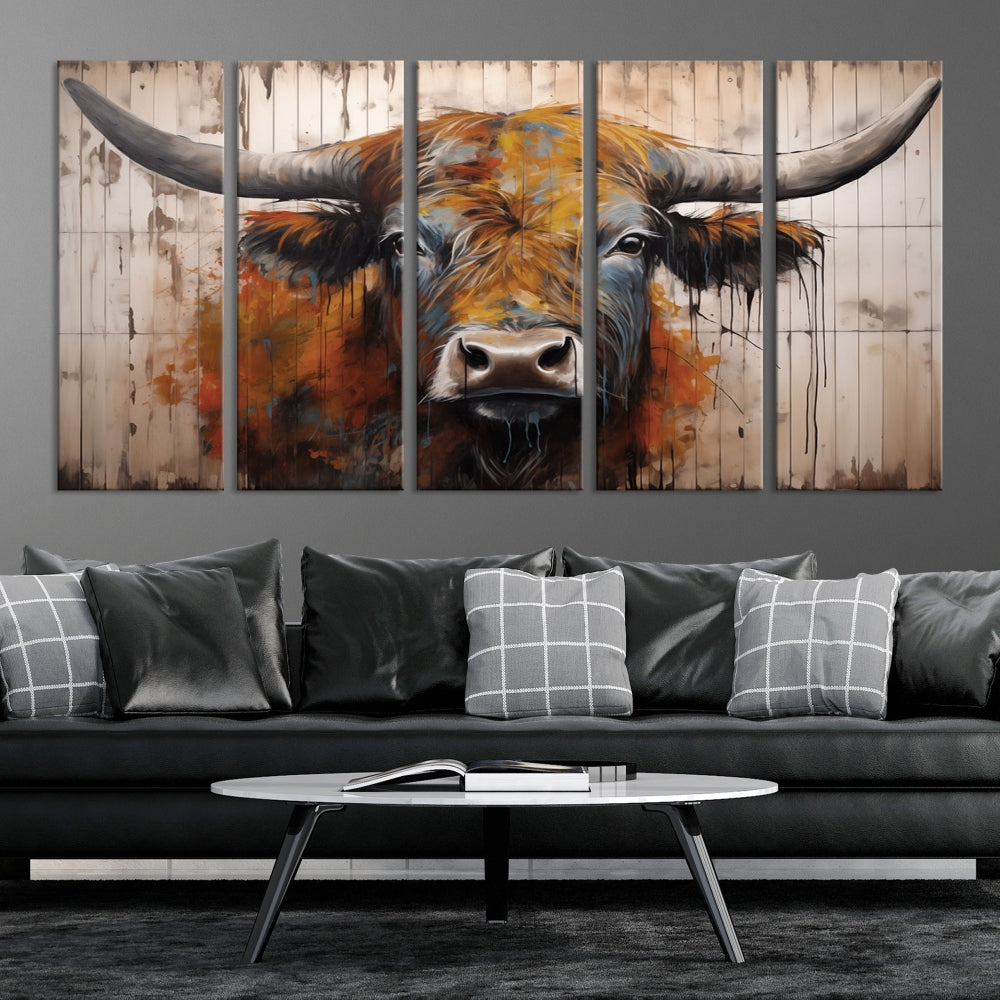 The "Abstract Bull Highland Cow Canvas Wall Art Print," displayed as a three-panel piece, adds vibrant rustic charm to a living room. Its depiction of a large, horned bull beautifully complements the elegance of modern farmhouse decor.