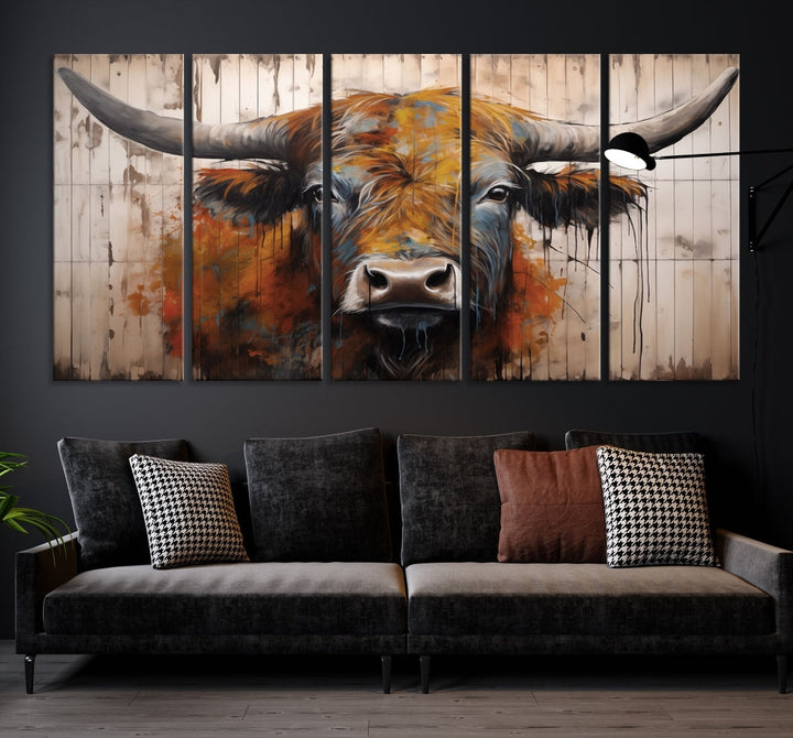 The "Abstract Bull Highland Cow Canvas Wall Art Print," displayed as a three-panel piece, adds vibrant rustic charm to a living room. Its depiction of a large, horned bull beautifully complements the elegance of modern farmhouse decor.