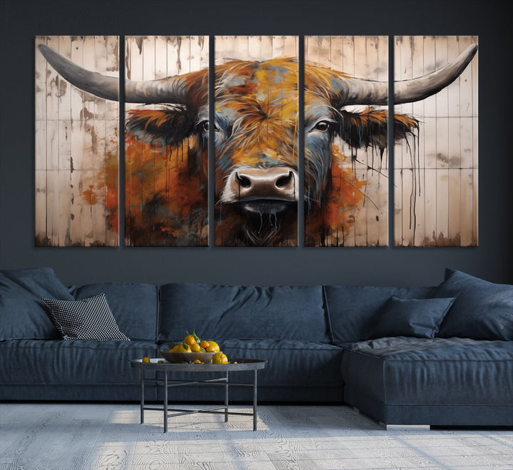 The "Abstract Bull Highland Cow Canvas Wall Art Print," displayed as a three-panel piece, adds vibrant rustic charm to a living room. Its depiction of a large, horned bull beautifully complements the elegance of modern farmhouse decor.