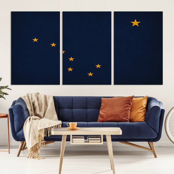 A contemporary living room featuring a triptych artwork of stars on a navy background, accentuated by the striking Alaska States Flag Wall Art Canvas Print.