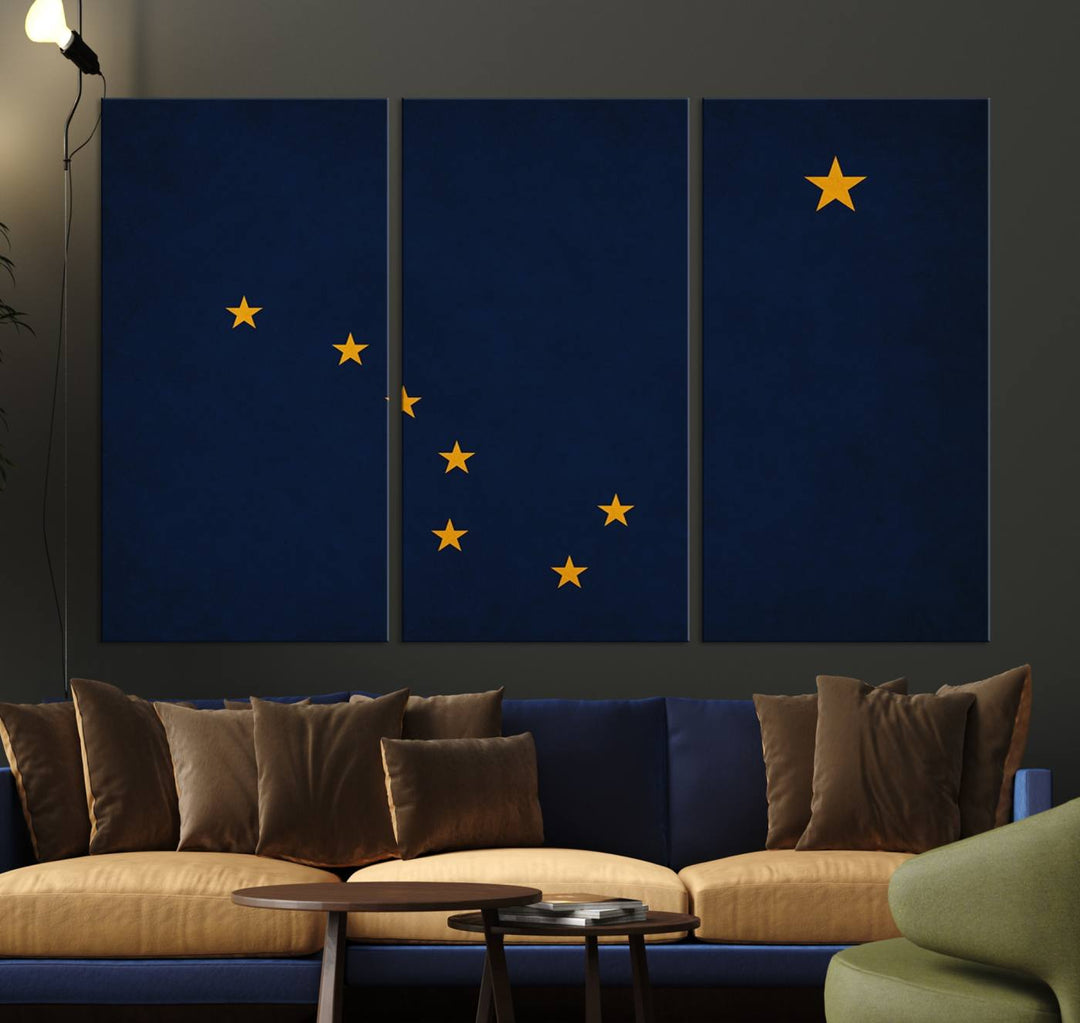 A contemporary living room featuring a triptych artwork of stars on a navy background, accentuated by the striking Alaska States Flag Wall Art Canvas Print.