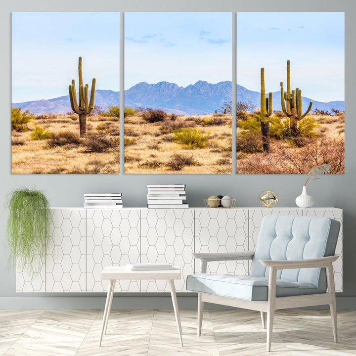 The Arizona Desert Cactus Wall Art Canvas Print, positioned above the console in a modern room, showcases a triptych desert landscape featuring cacti and mountains. Crafted on museum-quality polycotton canvas, it is finished with gallery-wrapped edges and an advanced UV-protective coating.