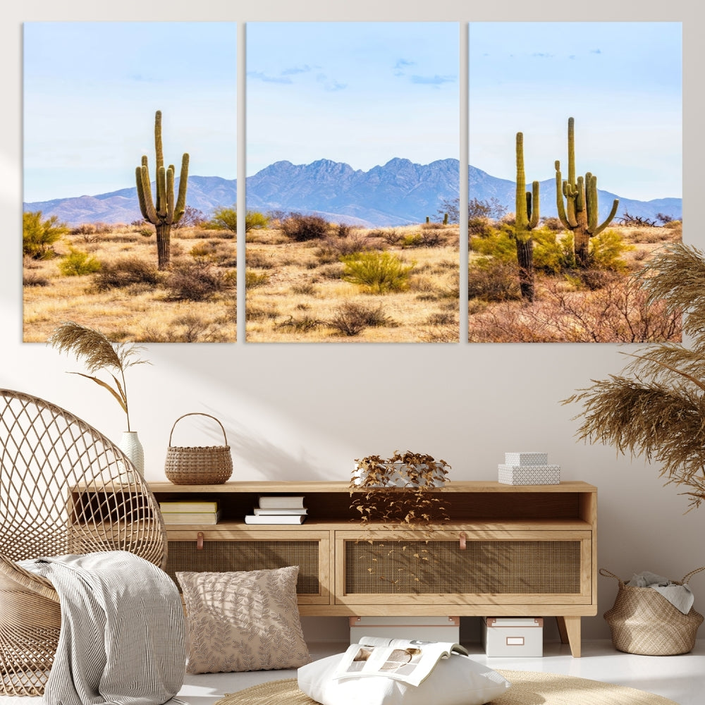 The Arizona Desert Cactus Wall Art Canvas Print, positioned above the console in a modern room, showcases a triptych desert landscape featuring cacti and mountains. Crafted on museum-quality polycotton canvas, it is finished with gallery-wrapped edges and an advanced UV-protective coating.