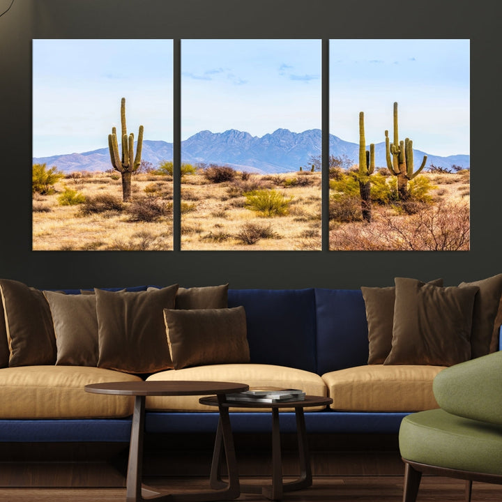 The Arizona Desert Cactus Wall Art Canvas Print, positioned above the console in a modern room, showcases a triptych desert landscape featuring cacti and mountains. Crafted on museum-quality polycotton canvas, it is finished with gallery-wrapped edges and an advanced UV-protective coating.