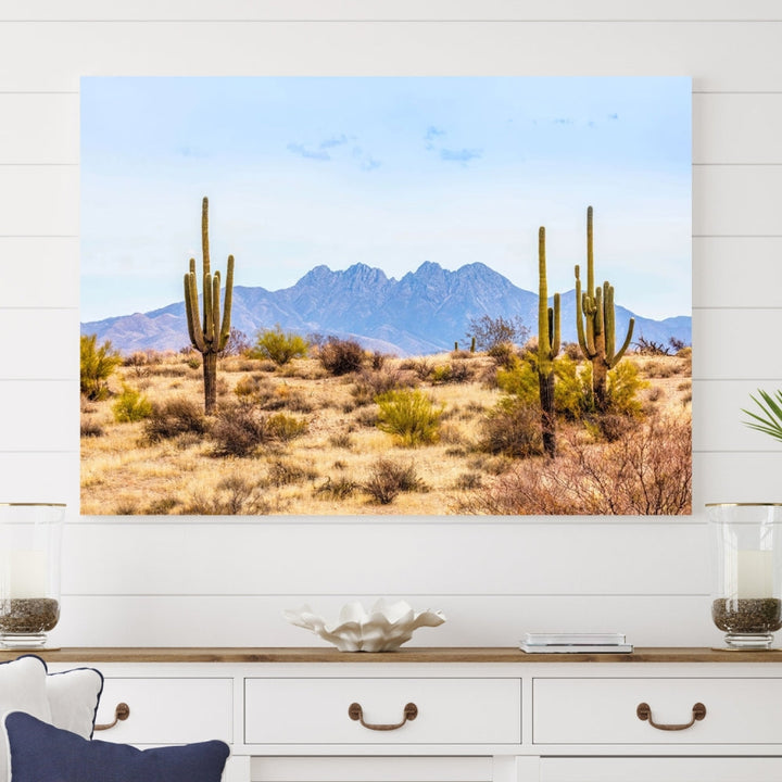 The Arizona Desert Cactus Wall Art Canvas Print, positioned above the console in a modern room, showcases a triptych desert landscape featuring cacti and mountains. Crafted on museum-quality polycotton canvas, it is finished with gallery-wrapped edges and an advanced UV-protective coating.