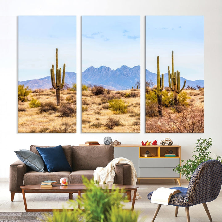 The Arizona Desert Cactus Wall Art Canvas Print, positioned above the console in a modern room, showcases a triptych desert landscape featuring cacti and mountains. Crafted on museum-quality polycotton canvas, it is finished with gallery-wrapped edges and an advanced UV-protective coating.