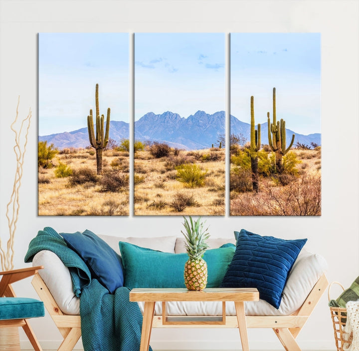 The Arizona Desert Cactus Wall Art Canvas Print, positioned above the console in a modern room, showcases a triptych desert landscape featuring cacti and mountains. Crafted on museum-quality polycotton canvas, it is finished with gallery-wrapped edges and an advanced UV-protective coating.