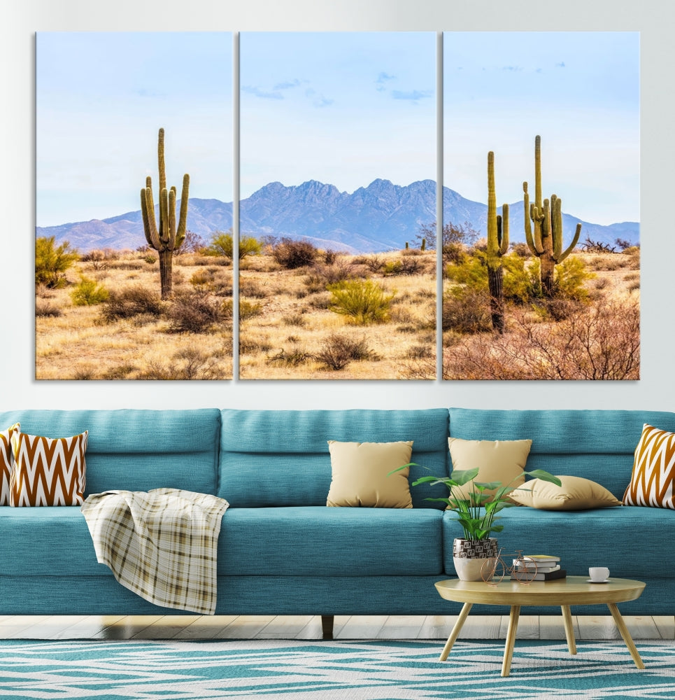 The Arizona Desert Cactus Wall Art Canvas Print, positioned above the console in a modern room, showcases a triptych desert landscape featuring cacti and mountains. Crafted on museum-quality polycotton canvas, it is finished with gallery-wrapped edges and an advanced UV-protective coating.