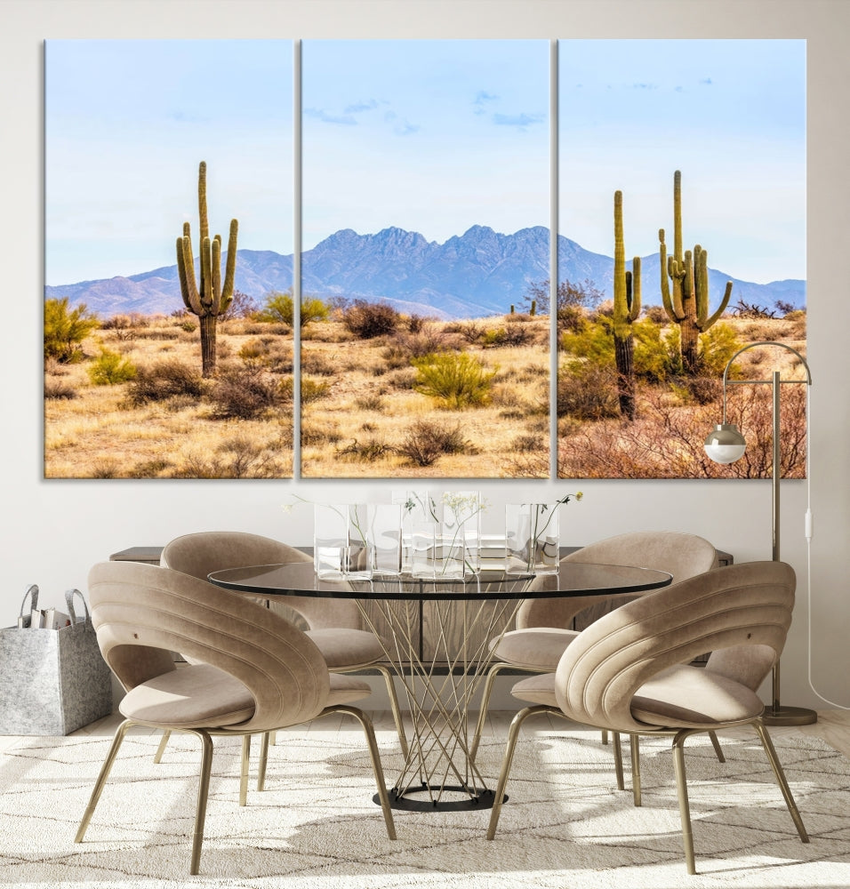 The Arizona Desert Cactus Wall Art Canvas Print, positioned above the console in a modern room, showcases a triptych desert landscape featuring cacti and mountains. Crafted on museum-quality polycotton canvas, it is finished with gallery-wrapped edges and an advanced UV-protective coating.