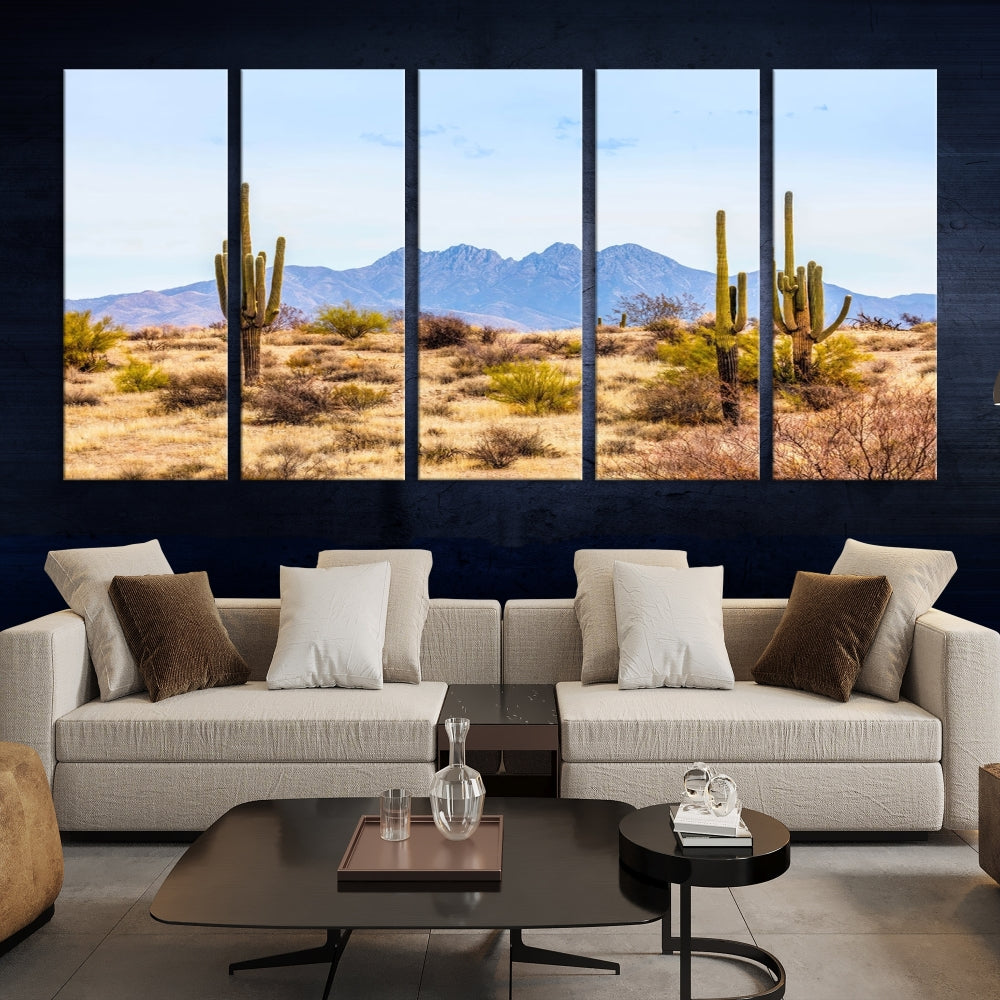 The Arizona Desert Cactus Wall Art Canvas Print, positioned above the console in a modern room, showcases a triptych desert landscape featuring cacti and mountains. Crafted on museum-quality polycotton canvas, it is finished with gallery-wrapped edges and an advanced UV-protective coating.