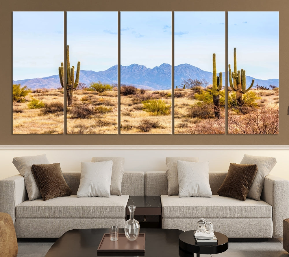 The Arizona Desert Cactus Wall Art Canvas Print, positioned above the console in a modern room, showcases a triptych desert landscape featuring cacti and mountains. Crafted on museum-quality polycotton canvas, it is finished with gallery-wrapped edges and an advanced UV-protective coating.