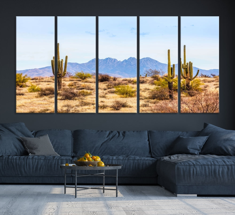 The Arizona Desert Cactus Wall Art Canvas Print, positioned above the console in a modern room, showcases a triptych desert landscape featuring cacti and mountains. Crafted on museum-quality polycotton canvas, it is finished with gallery-wrapped edges and an advanced UV-protective coating.