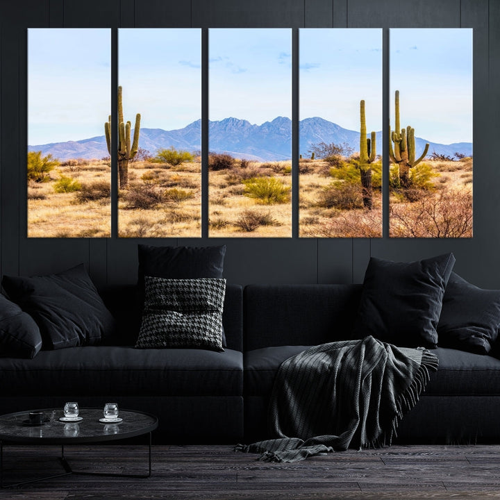 The Arizona Desert Cactus Wall Art Canvas Print, positioned above the console in a modern room, showcases a triptych desert landscape featuring cacti and mountains. Crafted on museum-quality polycotton canvas, it is finished with gallery-wrapped edges and an advanced UV-protective coating.