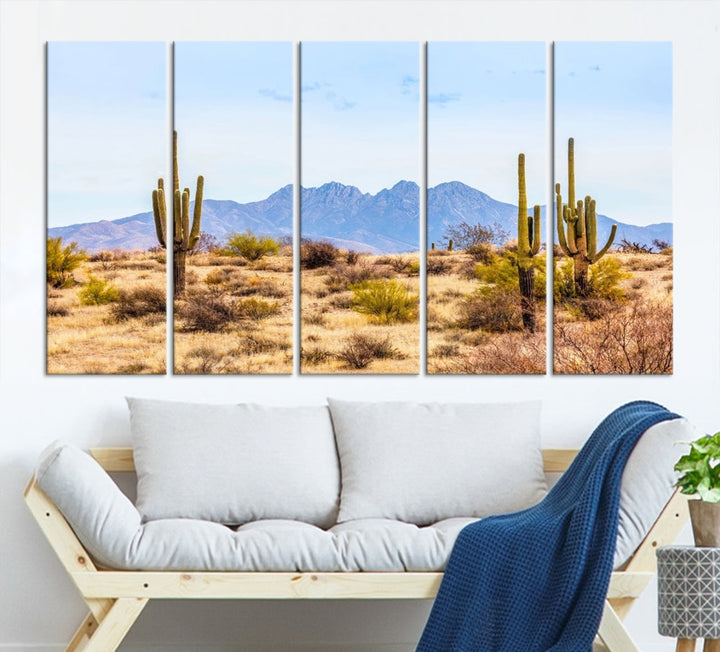 The Arizona Desert Cactus Wall Art Canvas Print, positioned above the console in a modern room, showcases a triptych desert landscape featuring cacti and mountains. Crafted on museum-quality polycotton canvas, it is finished with gallery-wrapped edges and an advanced UV-protective coating.