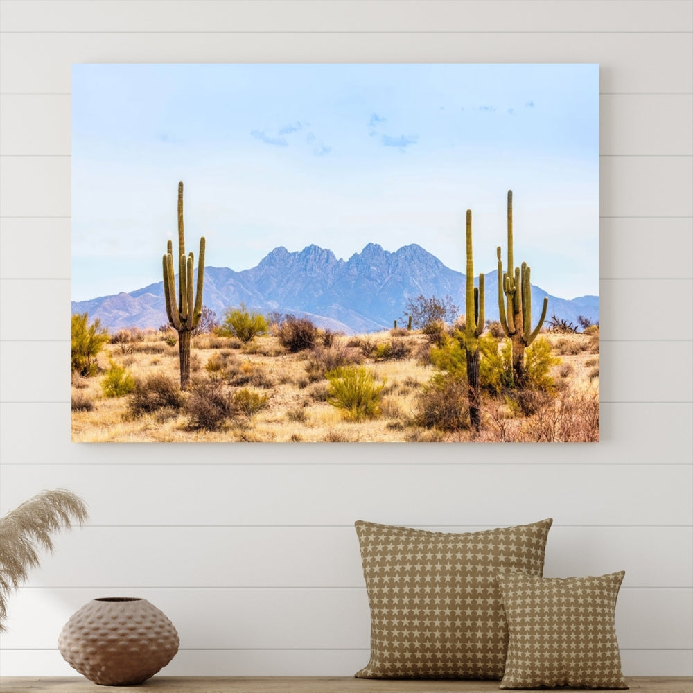 The Arizona Desert Cactus Wall Art Canvas Print, positioned above the console in a modern room, showcases a triptych desert landscape featuring cacti and mountains. Crafted on museum-quality polycotton canvas, it is finished with gallery-wrapped edges and an advanced UV-protective coating.