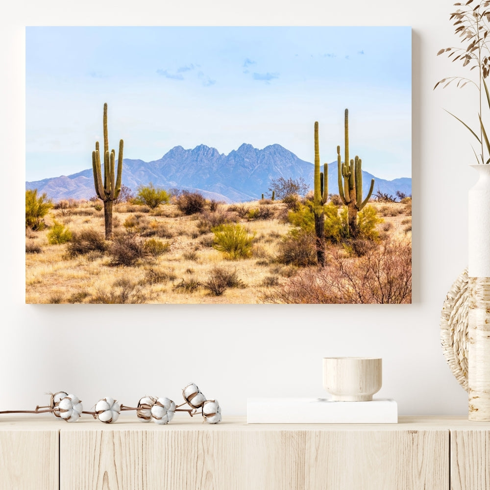 The Arizona Desert Cactus Wall Art Canvas Print, positioned above the console in a modern room, showcases a triptych desert landscape featuring cacti and mountains. Crafted on museum-quality polycotton canvas, it is finished with gallery-wrapped edges and an advanced UV-protective coating.