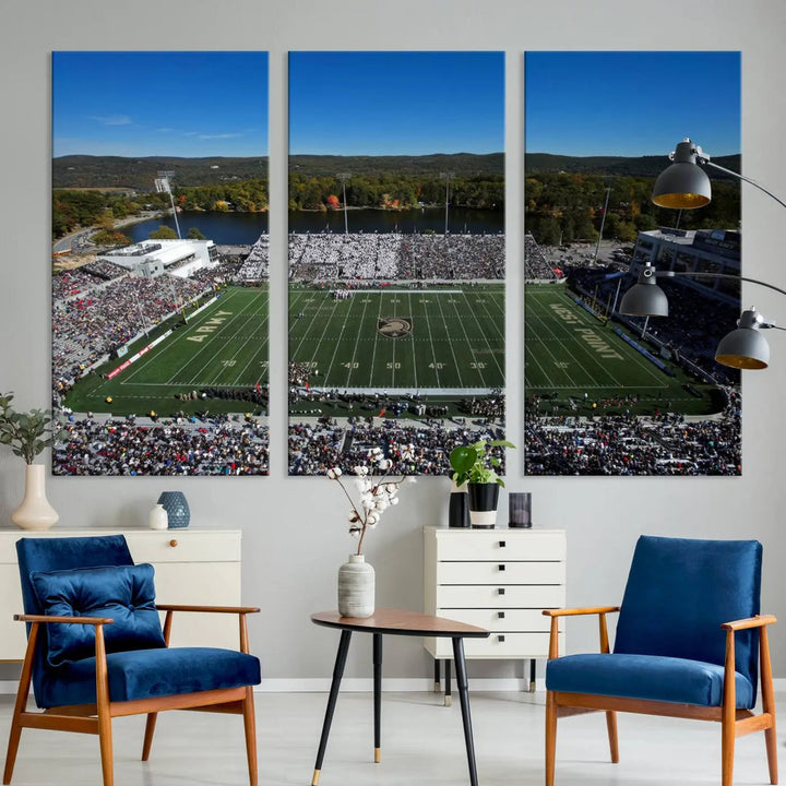 The Army Black Knights Football Team Print on West Point Michie Stadium is showcased with an aerial view capturing a lively football stadium surrounded by lush trees and a river. This wall art is printed on museum-quality canvas and mounted on a stretched wood frame.