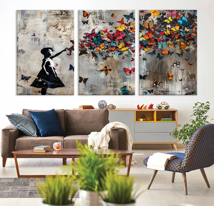 The Banksy Butterfly Girl 3-piece canvas art showcases a silhouette of a girl surrounded by colorful butterflies, perfect for modern living room decor.