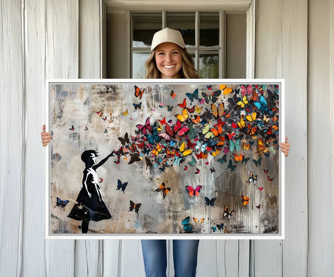 A person holding the Banksy Butterfly Girl Graffiti Canvas Wall Art.