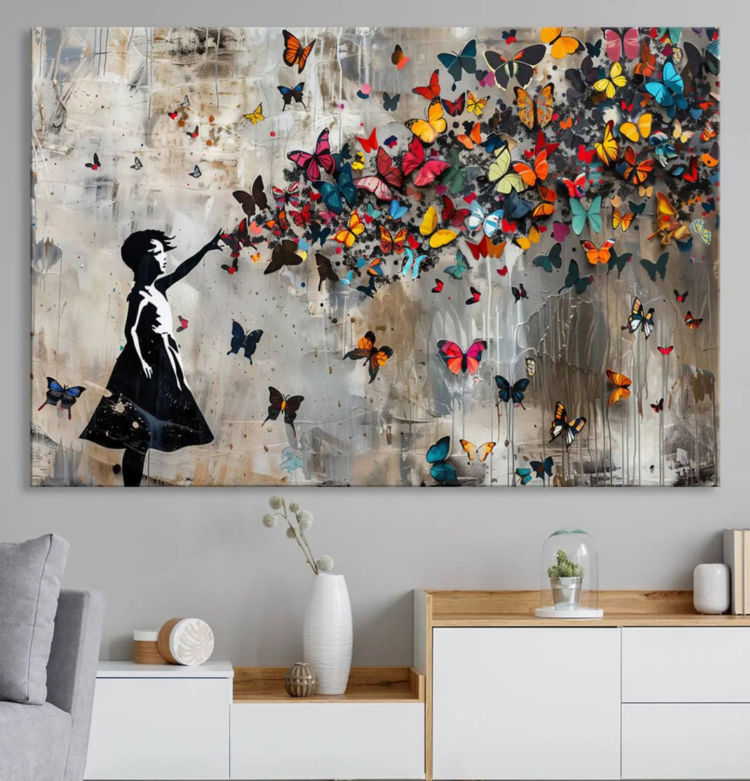 The Banksy Butterfly Girl 3-piece canvas art showcases a silhouette of a girl surrounded by colorful butterflies, perfect for modern living room decor.