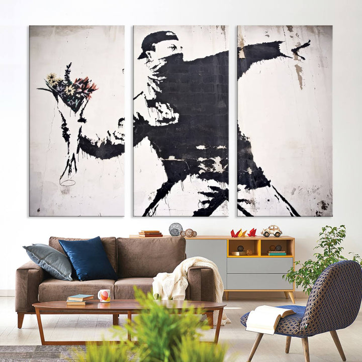 The living room features a split-panel art piece named "Banksy Flower Throw Graffiti Street Wall Art Canvas Print," gallery wrapped on museum-quality polycotton canvas and accentuated by modern decor elements.