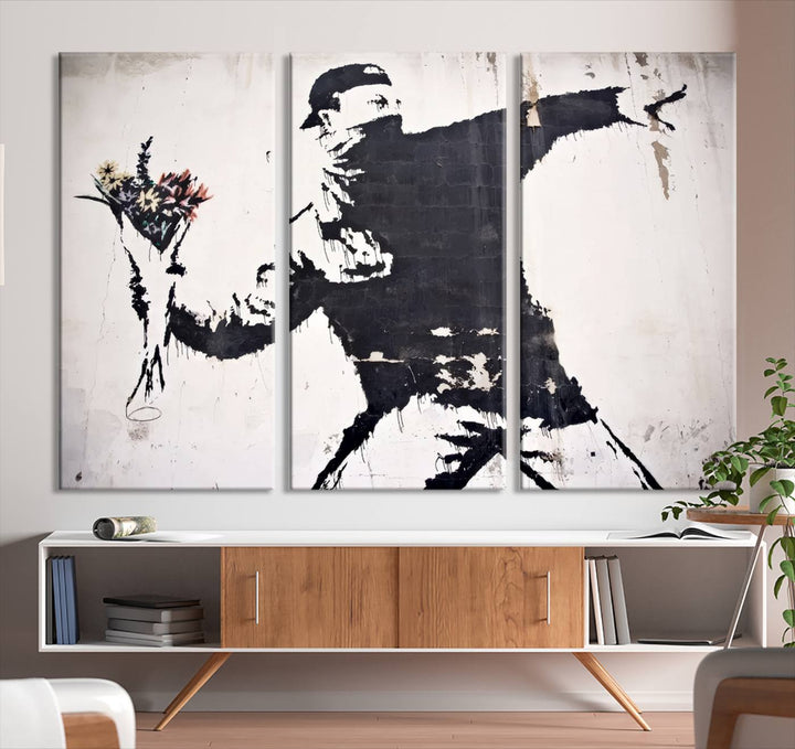 The living room features a split-panel art piece named "Banksy Flower Throw Graffiti Street Wall Art Canvas Print," gallery wrapped on museum-quality polycotton canvas and accentuated by modern decor elements.