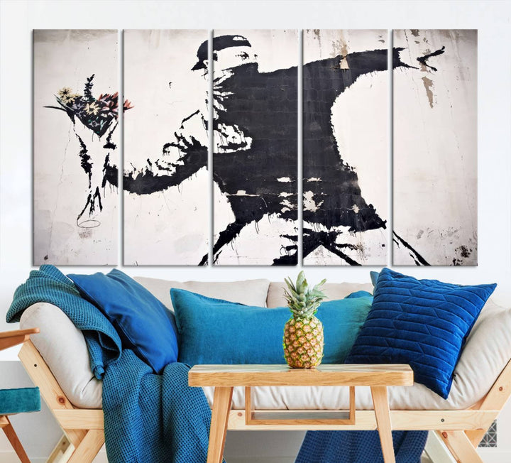 The living room features a split-panel art piece named "Banksy Flower Throw Graffiti Street Wall Art Canvas Print," gallery wrapped on museum-quality polycotton canvas and accentuated by modern decor elements.