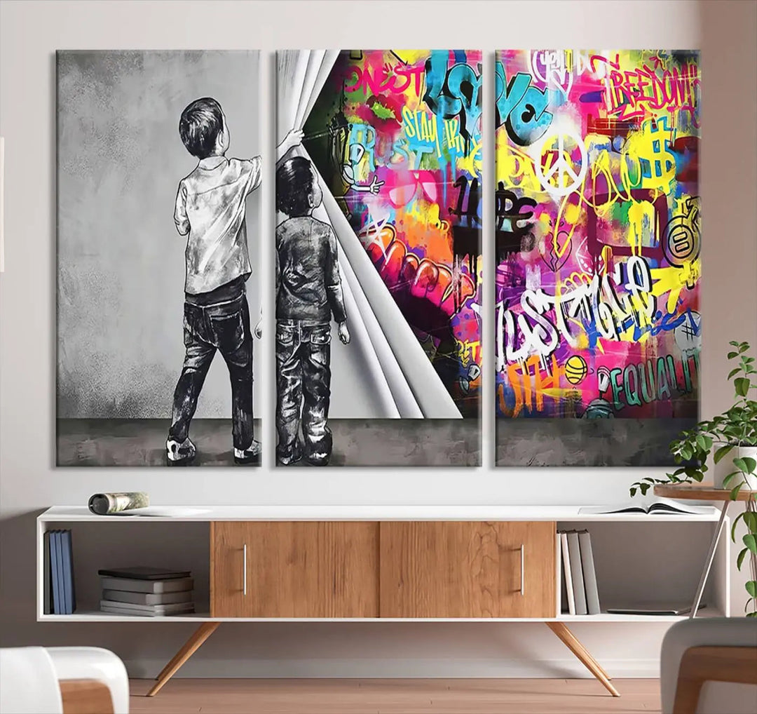 The Banksy Print - Street Art Canvas features a vibrant and bold image of two children lifting a curtain to reveal colorful graffiti. It's ready to hang, adding an urban modern decor vibe.