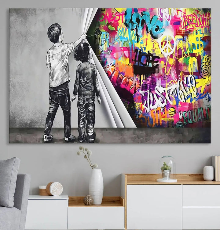 The Banksy Print - Street Art Canvas features a vibrant and bold image of two children lifting a curtain to reveal colorful graffiti. It's ready to hang, adding an urban modern decor vibe.