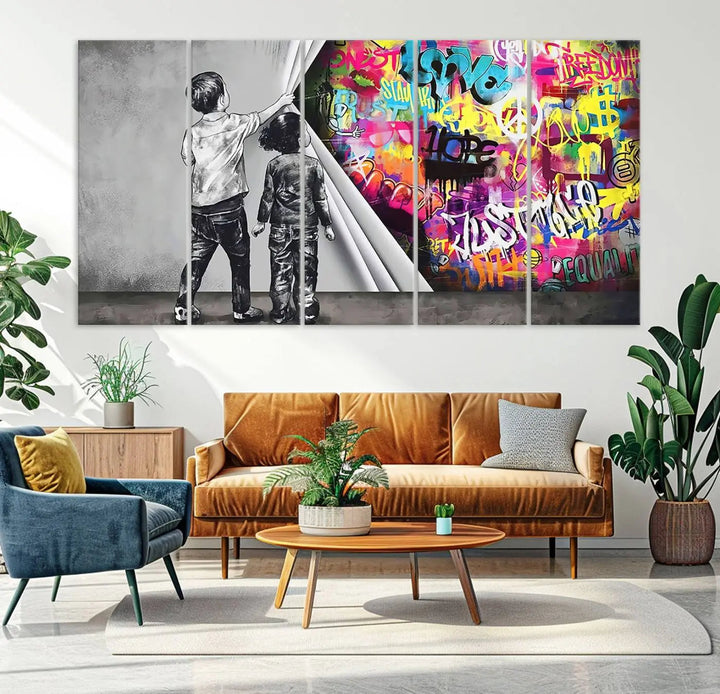 The Banksy Print - Street Art Canvas features a vibrant and bold image of two children lifting a curtain to reveal colorful graffiti. It's ready to hang, adding an urban modern decor vibe.